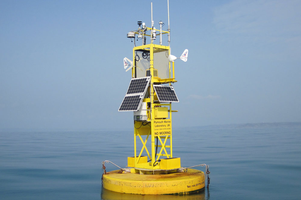 Picture of a yellow scientific data buoy at sea