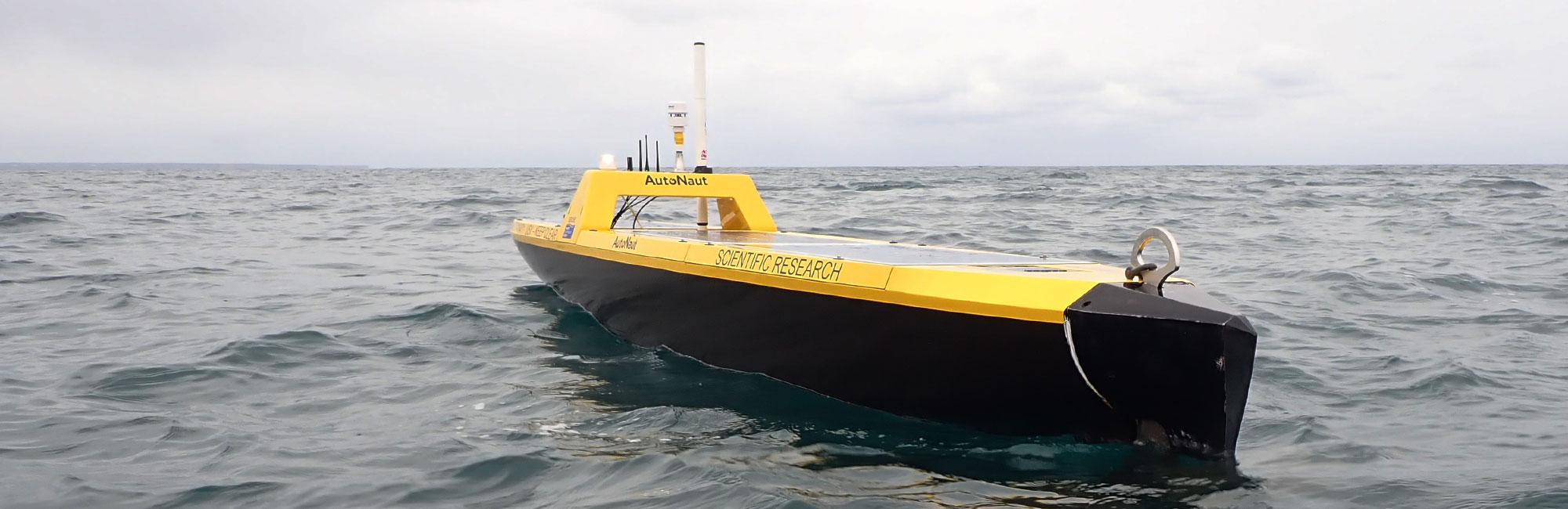 Yellow AutoNaut autonomous vessel on the sea surface close up